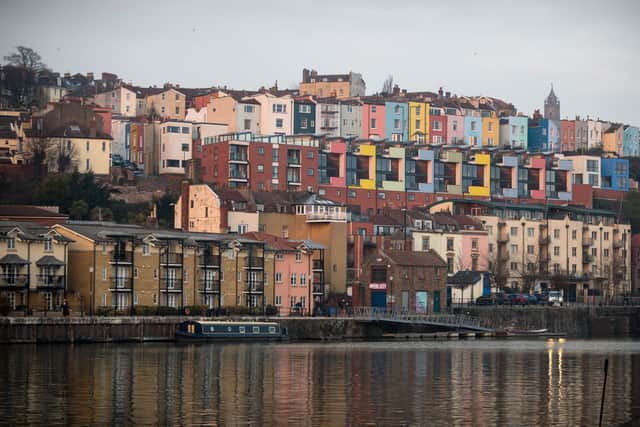 The setting sun is reflected in the windows of houses built besides the river in Bristol.