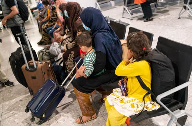 Afghan refugees wait to be processed after arriving on an evacuation flight from Afghanistan, at Heathrow Airport (Photo by DOMINIC LIPINSKI/POOL/AFP via Getty Images)