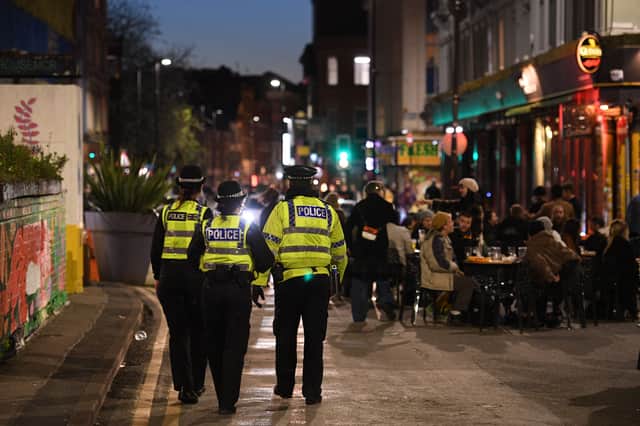 Police officers patrol the streets where customers are enjoying drinks at tables outside the pubs (Photo by Oli SCARFF / AFP) (Photo by OLI SCARFF/AFP via Getty Images)