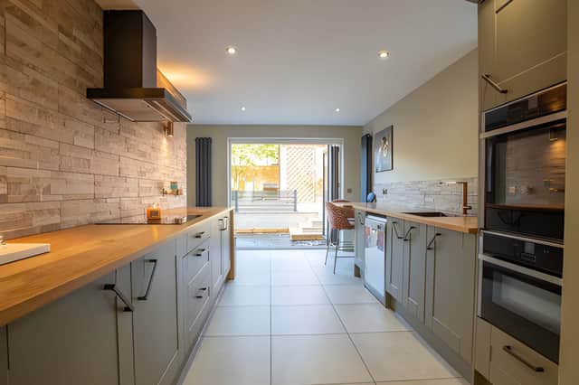 Bifold doors connect the fitted kitchen with the enclosed rear garden
