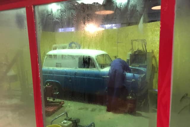 A static display of man working on an original 1956 Ford 300 E work van that the Gilks family used at garage.