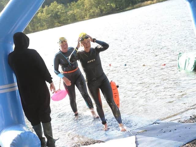 Jane Ablett walks out of the water after an end-to-end swim of Lake Coniston