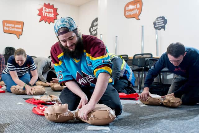 Amazon operations supervisor Lloyd Curley practising CPR on a dummy