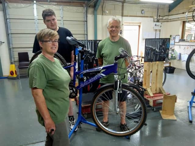 Left to right, Brigitte Hickman, trainee Mattew Young and volunteer mechanic Kevin Arnold at The Windrush Bike Project
