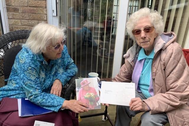 Edith Dumbleton (left) with her twin sister, Dorcas Tobin, as they hold the letter from the Queen they each received marking their 100th birthday.