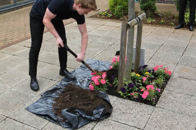 Charlie Willis, sixth form ambassador, burying the time capsule at Chenderit School
