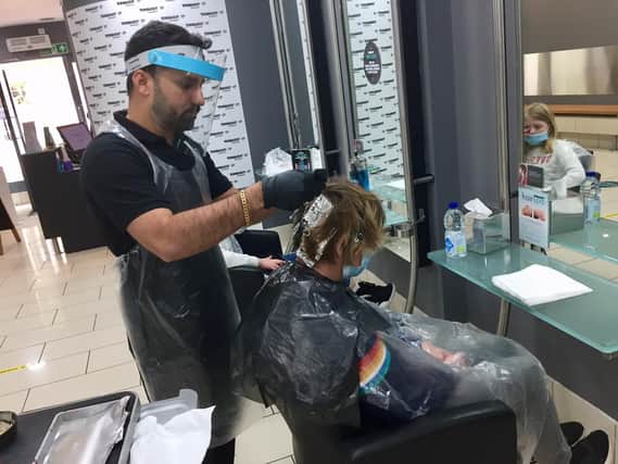 HiteshRavrani, the owner of the Toni & Guy hair salon in the Banbury town centre, works on a customer's hair