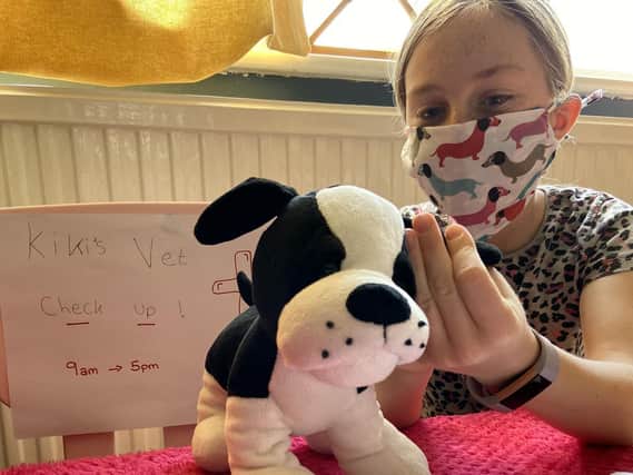 Kiki Malloy uses her handmade mask to examine her cuddly animals