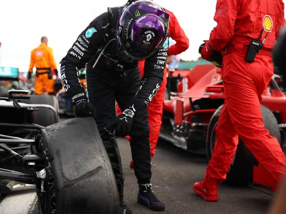 Lewis Hamilton checks out his flat tyre