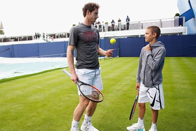 Talented tennis player Romeo Beckham gets some tips from Wimbledon legend Andy Murray. Picture by Getty