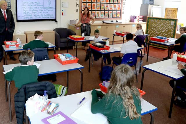 Prime Minister Boris Johnson said it was a national priority to get children back to school in September. Here is watches a distanced lesson in a Hemel Hempstead school. Picture by Getty