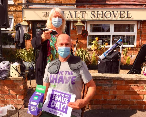 Sue Middleditch shaves Mark Charnock's head as part of the 'Brave the Shave' fundraising challenge held to help Macmillan Cancer Support