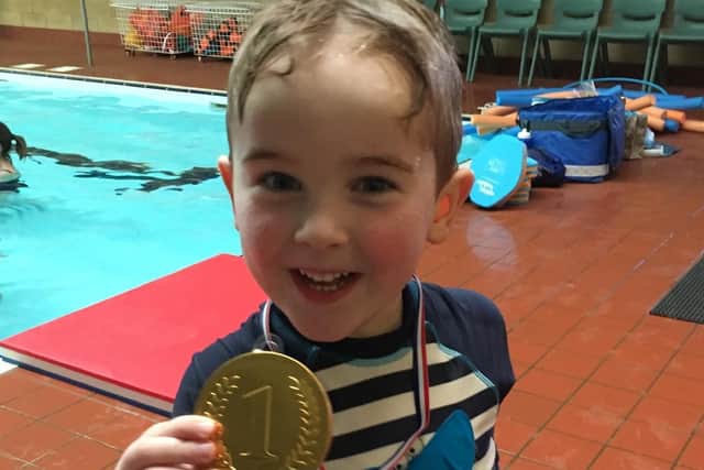 Waterbaby Charlie Wood, aged five, with his graduation medal