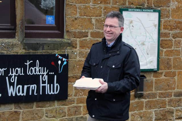 MP Jeremy Wright carries a take-away breakfast from the launch of the Warm-Hub event at Shottswell Village Hall