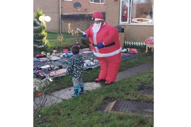 Matthew Hextall collects a present from Prabhu Natarajan, who dressed as Santa to help raise the Christmas spirit in his Bretch Hill, Banbury neighbourhood
