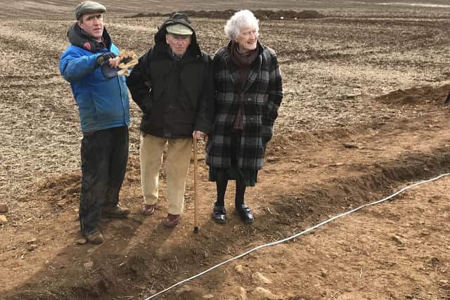 Martin Fiennes shows his parents, Lord and Lady Saye and Sele, around the excavation site during the trial dig on their estate