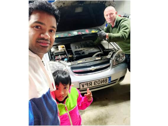 Prabhu Natarajan with his son Addhu next to Damian Leaver, who helped fix Prabhu's car with a free oil change among other items
