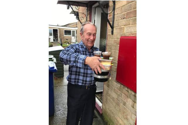 A man smiles as he receives a meal from the 'Valentine's Bangers and Mash' initiative launched by the Brackley Elves community group
