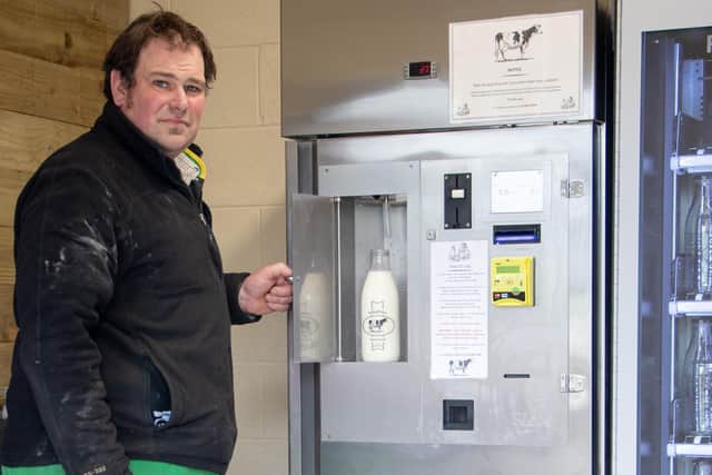 Dairy farmer Ben Coles shows off his new milk vending machine which is proving popular with customers