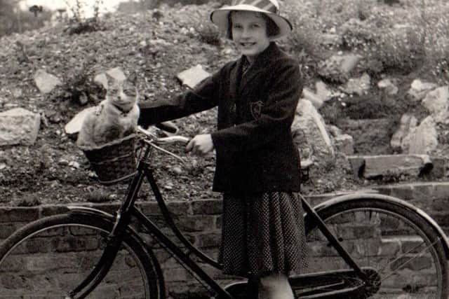 Sylvie Nickels, aged ten, during wartime with her cat Topsy in the basket of her bicycle