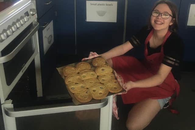 Kay Goodwill pulls a tray of cookies out of an oven