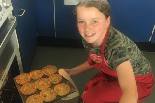 Olivia Smith pulls cookies out of an oven to give away to the elderly