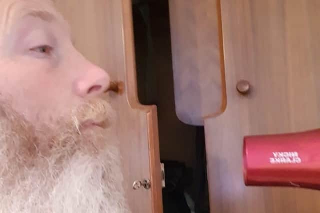 Kevin Cairns gives his beard one last blow dry before its shaved off