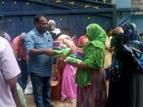 Fieldworker Rajan Jayakumar hands out essential supplies to help one of the many needy families