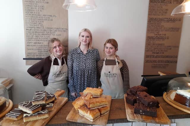 Ellie Harper, the owner of the Adderbury business - Harper's Coffee House - stands with staff members Bo and Grace.