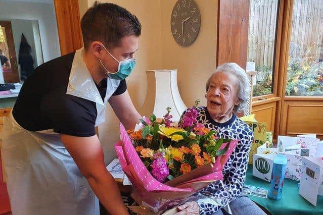 Adelaide 'Addie' Furnivall receives flowers on her 100th birthday.