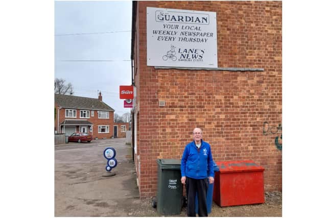 Barry Lane stands underneath a Banbury Guardian sign outside his newsagents, Lane's News, in the Easington community of Banbury