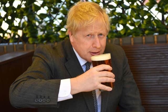 Boris Johnson, in happier times, drinking a pint of beer on a regional visit to the Midlands. Picture by Getty