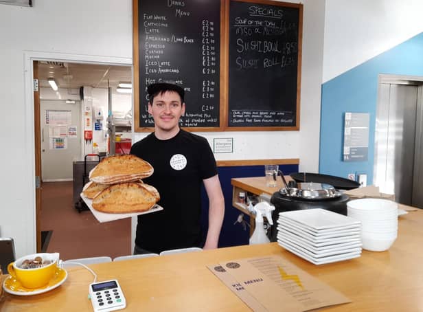 Callum Smith holds a loaf of homemade bread behind the counter at the Pavement Coffee Co. café, which he runs with his wife, Jane Marker, in the town centre of Banbury
