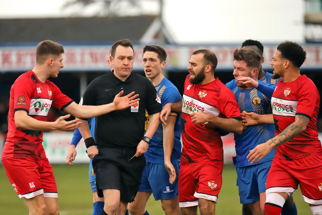 The players surround the referee as he decides to produce a red card for Connor Kennedy