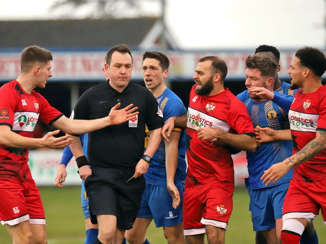 The players surround the referee as he decides to produce a red card for Connor Kennedy