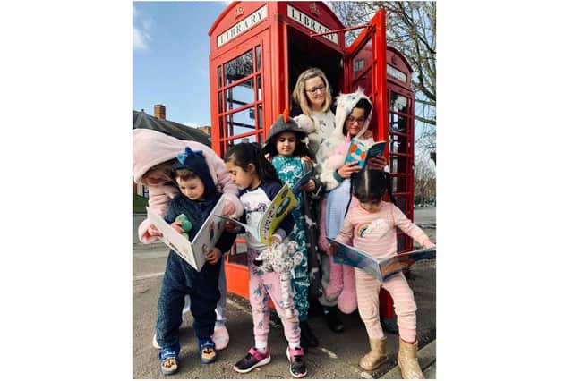 Mrs Tracey Wilson, the headmistress at St John’s Priory School, celebrates National Storytelling Week with some pupils at the phone box library in Banbury (Submitted photo)