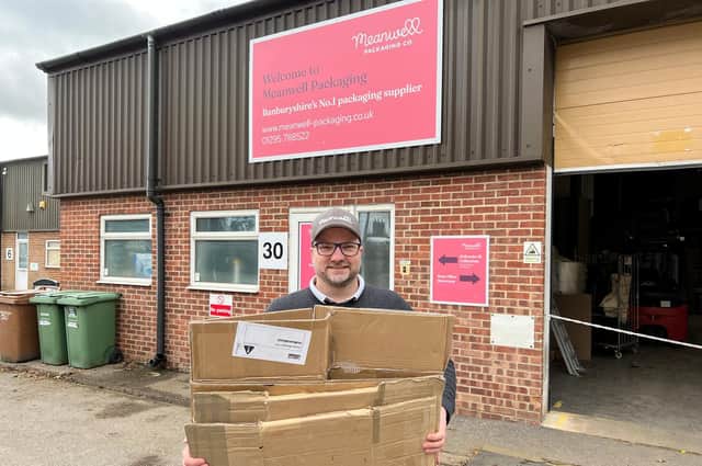 Company Director Tjobbe Andrews holds cardboard boxes outside the Meanwell Packaging offices. (Submitted photo)