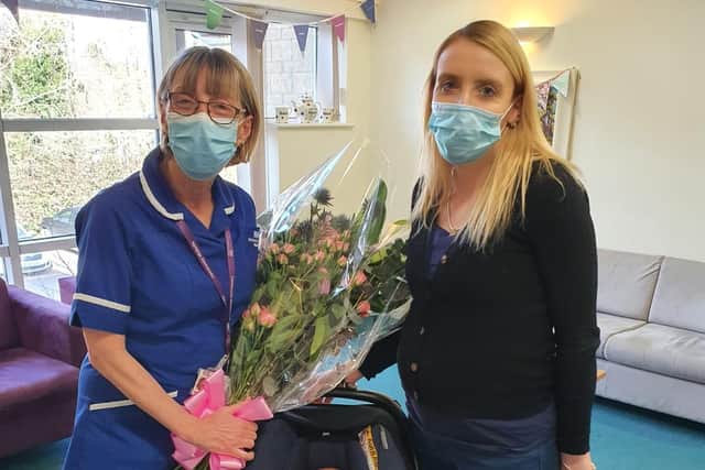 Carly Roberts presents her community midwife with a bouquet to thank her for her exceptional service