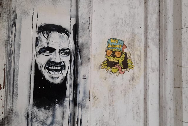 Street art found on a door facing the market place in the Banbury town centre showing Jack Nicholson's character from The Shining film