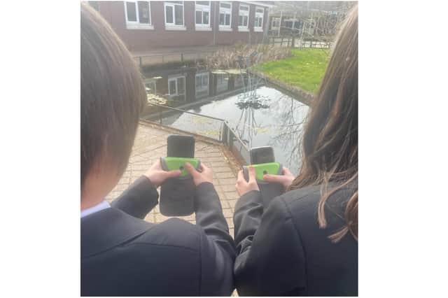 The Warriner School sees success with phone-free space scheme using Yondr phone case - pictured: Two students hold a Yondr case (photo from The Warriner School)