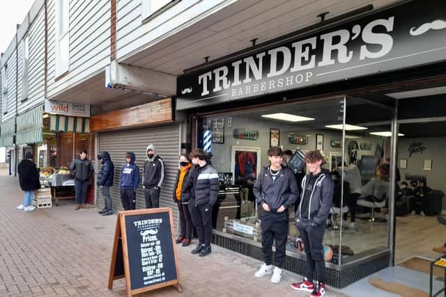 Nearly a dozen people wait for a haircut outside Trinder's barbers in Church Lane, Banbury