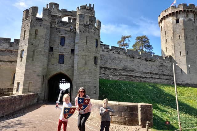 Eowyn and Hope Elofson ready for action with their mum, Liz Host at the entrance of Warwick Castle