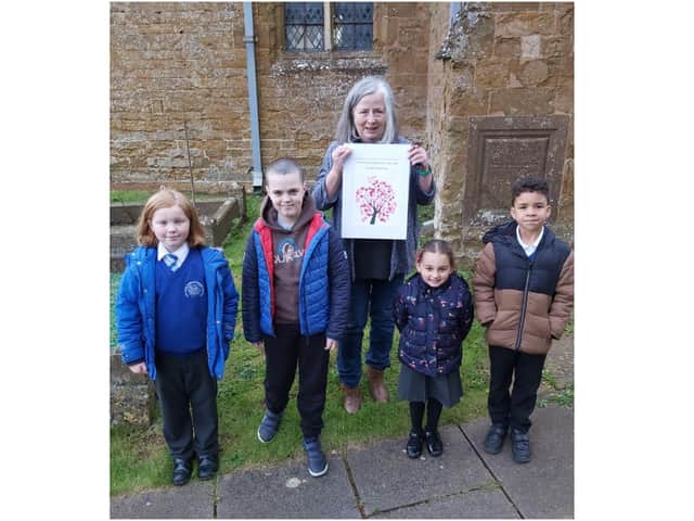 Wroxton Primary School pupils: Riley Powell, Aidan Parker, Ioana Let and Blake Mukombe, pictured with Reverend Alicia holding her picture of a Cherry Blossom tree, which every child in school contributed to. (Image from Wroxton Primary School)