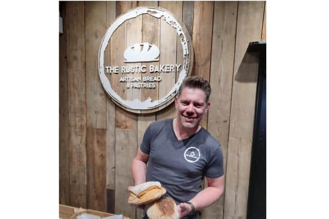 Stacy Parsons, the owner of The Rustic Bakery, holds some of the sourdough bread he will offer as the new town's bakery, which opens Saturday May 15.