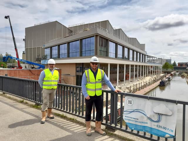 Chris Hipkiss, with Cherwell District Council, and Ben Parker with McLaren construction company stand on a bridge over the canal at the Castle Quay waterfront development