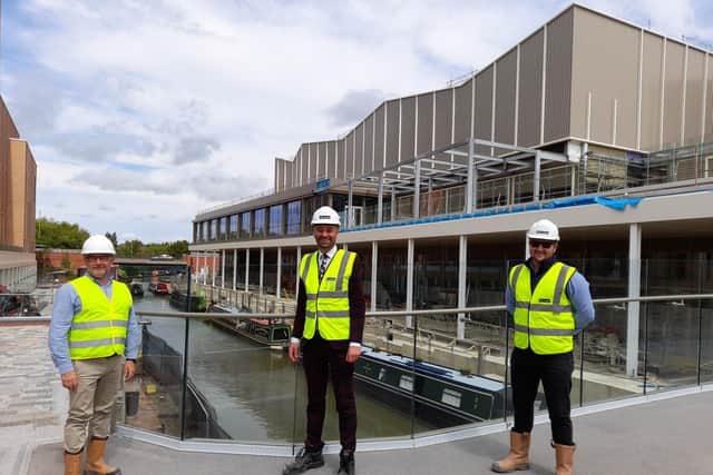 Chris Hipkiss, with Cherwell District Council, Oliver Wren, the director of Castle Quay Shopping Centre, and Ben Parker with McLaren Construction Company stand in front of the new Castle Quay Waterfront development.