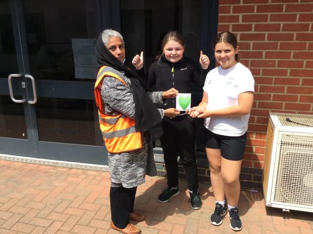 Nadra Masood (a lunchtime supervisor) receiving her thank you heart message from Isobel White and Julie Rutowska in year six at Dashwood Academy Banbury as part of Thanks a Teacher Day