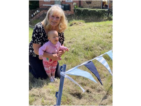 Bobbie Brown shows her granddaughter ‘Georgina’ the bunting she made at the Bourtons’ Big Bunting Bee project (submitted photo)