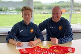 Morgan Roberts signs for Banbury United with manager Andy Whing (Picture courtesy of Banbury United)