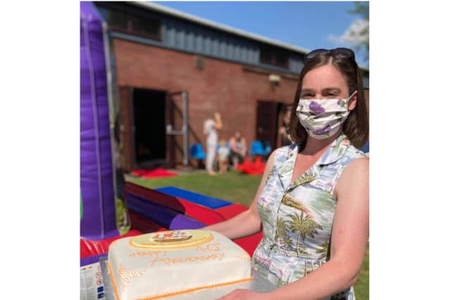 Emma Weir, the chair of the Kineton Baby and Toddler group, holds the cake for the 40th anniversary celebrations held on July 19